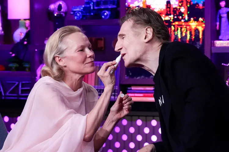 Flirt live në studio! Pamela Anderson “tundon” Liam Neeson me buzëkuqin e saj