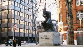 Statuja me firmën e Banksyt shfaqet në Londër/ Vepra misterioze paraqet një burrë me flamur që i mbulon fytyrën