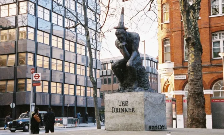 Statuja me firmën e Banksyt shfaqet në Londër/ Vepra misterioze paraqet një burrë me flamur që i mbulon fytyrën