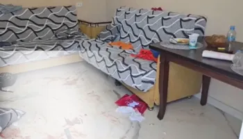 Tavolina e shtruar me ushqim, lodra dhe pllakat e lara me gjak në banesën e 32-vjeçares