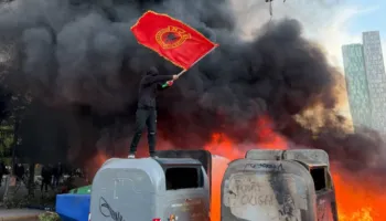 VIDEO/ Protestuesi i maskuar valëvit flamurin e UÇK-së mbi koshat që digjen